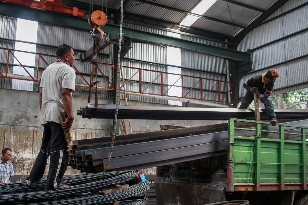 About CV. Baja Sakti Utama 1 Para pekerja di CV. Baja Sakti Utama sedang memuat batang besi ke atas truk di dalam sebuah gudang. Seorang pekerja mengawasi proses pengangkatan besi menggunakan alat crane, sementara pekerja lain memastikan besi ditempatkan dengan benar di atas truk.